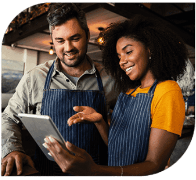 A man and woman looking at an ipad.