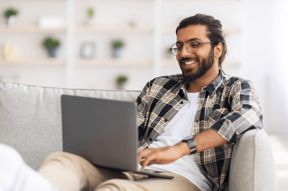 A man sitting on the couch with his laptop