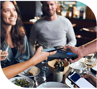 A woman paying for food at a restaurant table.