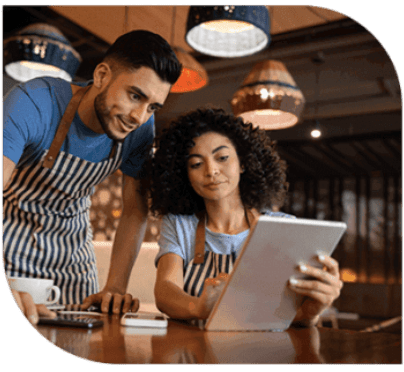 A man and woman looking at an ipad.