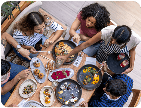 A group of people sitting around a table with food.