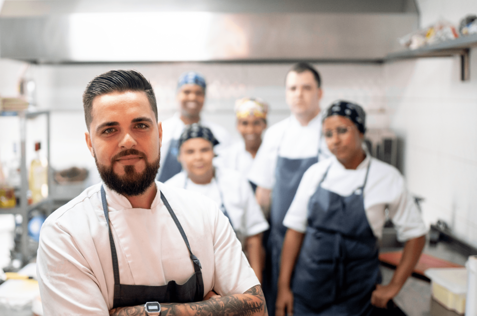 A group of chefs in a kitchen posing for the camera.