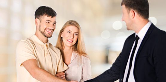 A man shaking hands with two women.