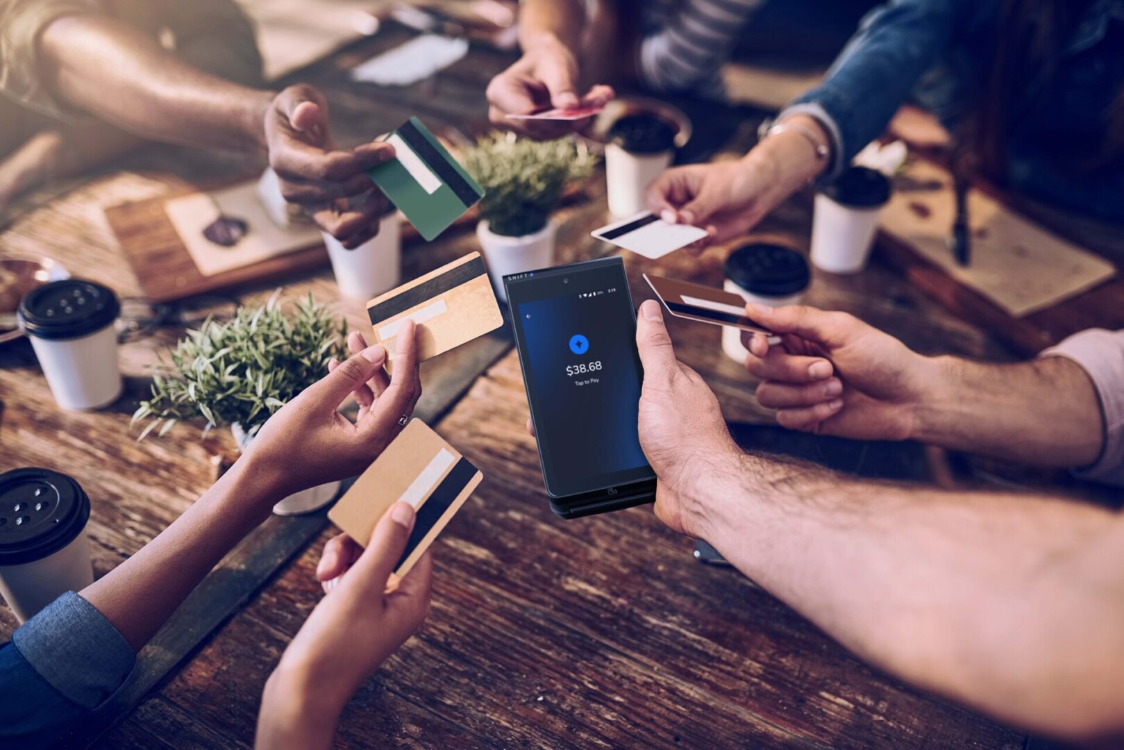 A group of people sitting around a table with phones.