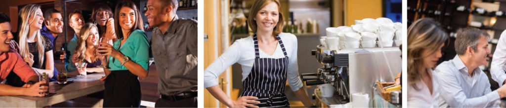 A woman in an apron standing next to a counter.