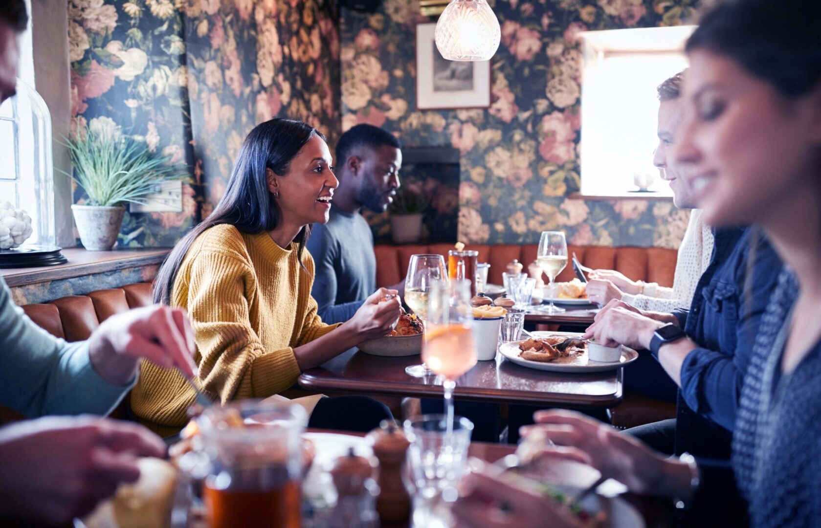 A group of people sitting at tables eating food.