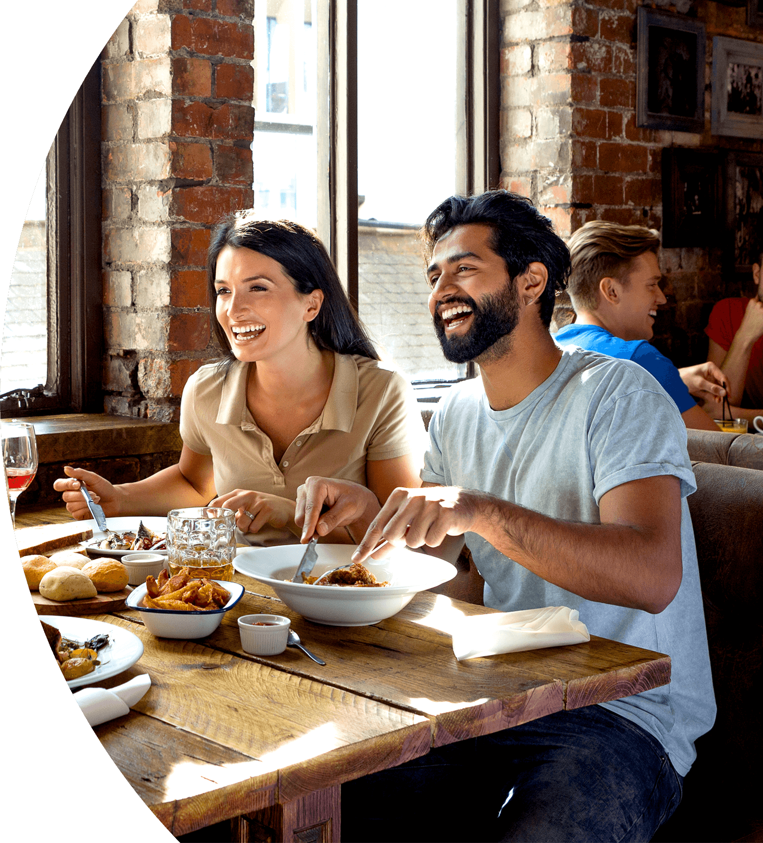 A man and woman sitting at a table with plates of food.