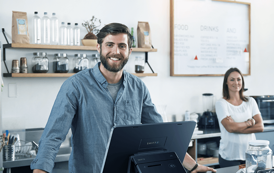 Man smiling at counter in a cafe.