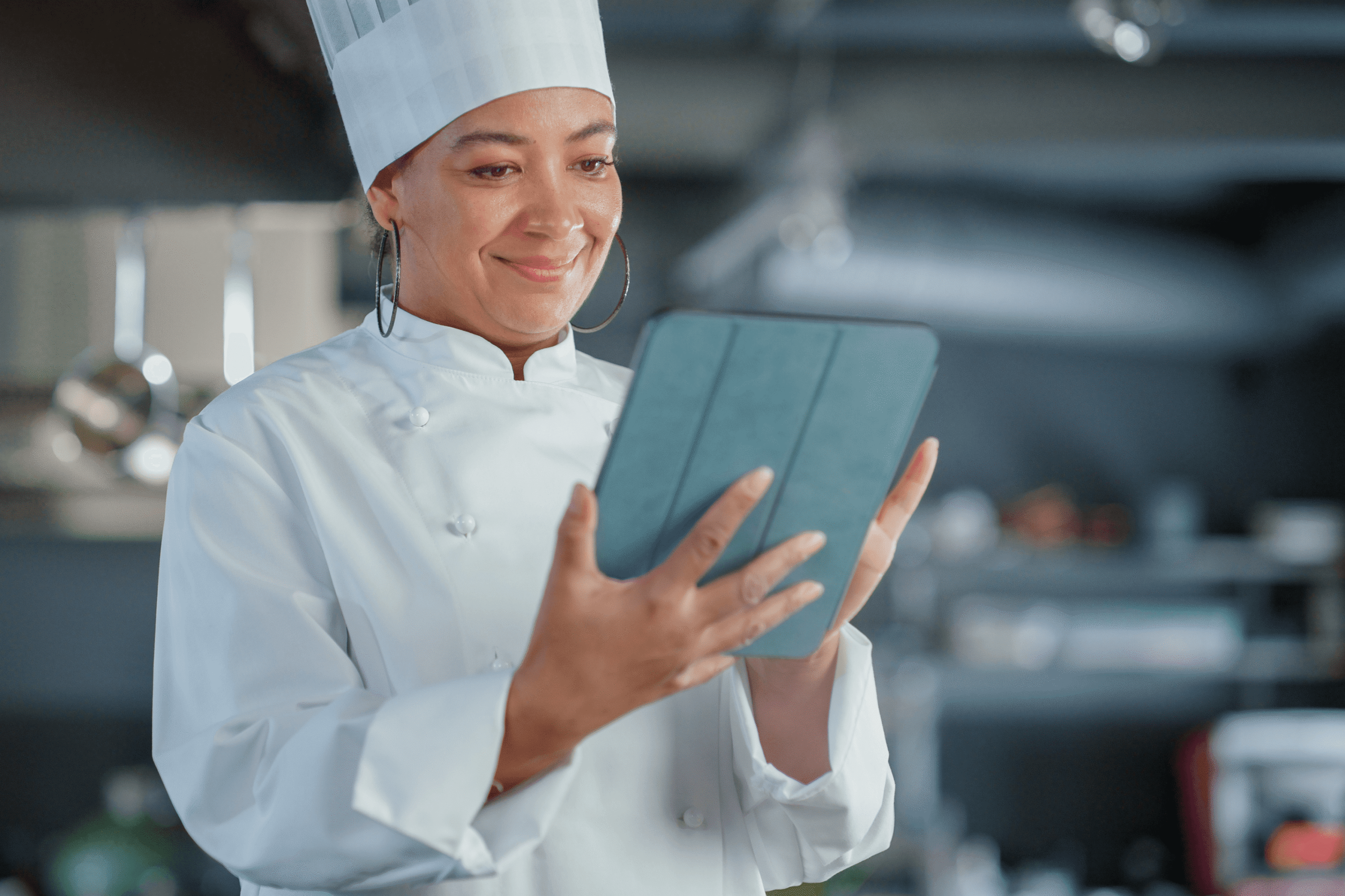 Chef using a tablet in kitchen.