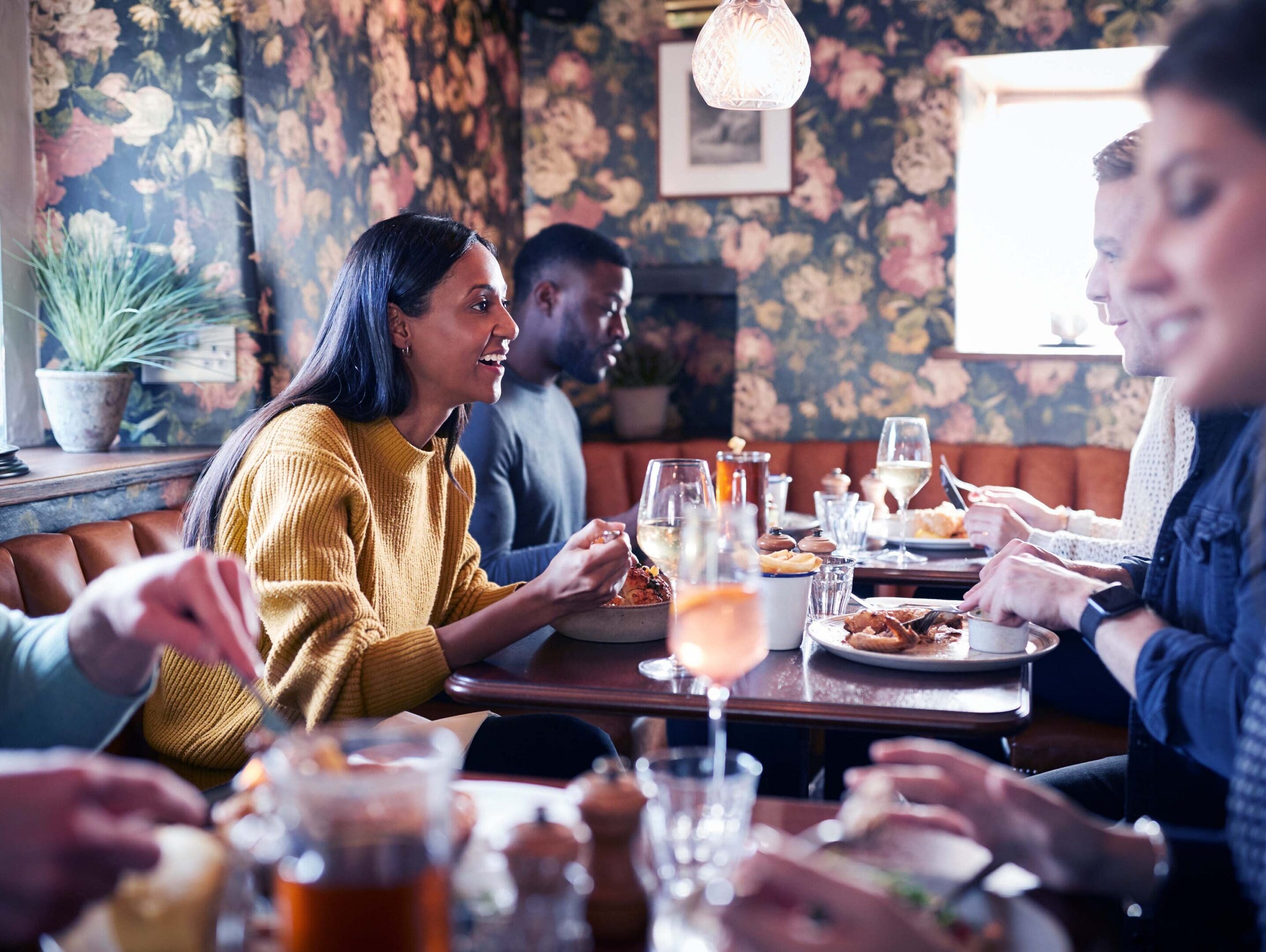 Friends dining at a cozy restaurant table.