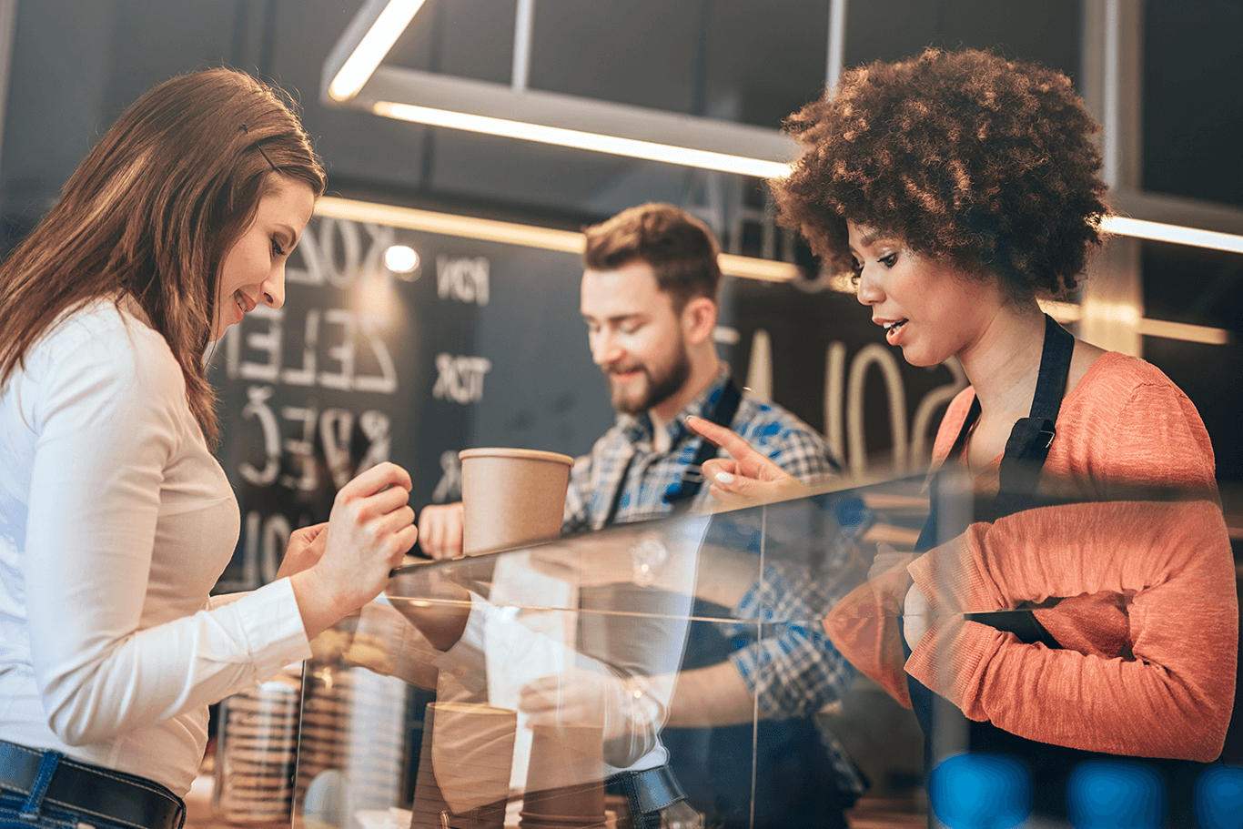 Customers ordering at a coffee shop counter.
