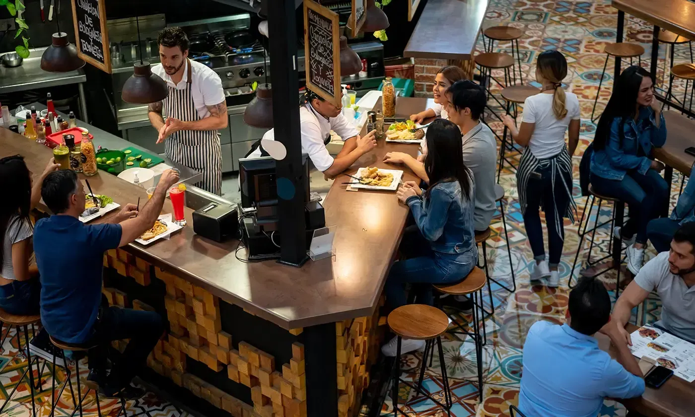 People dining at a busy restaurant counter.