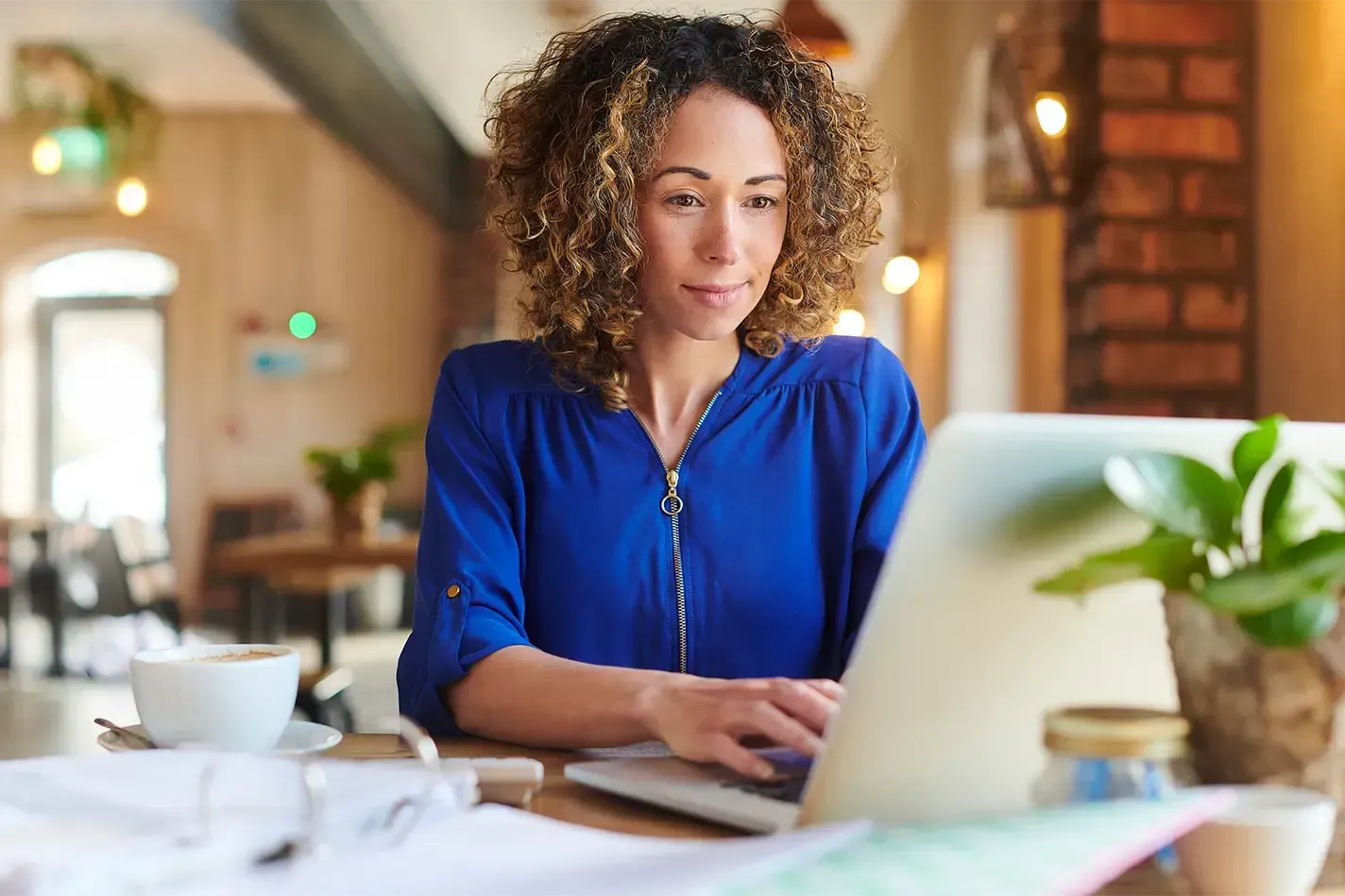 Woman in blue shirt using a laptop.