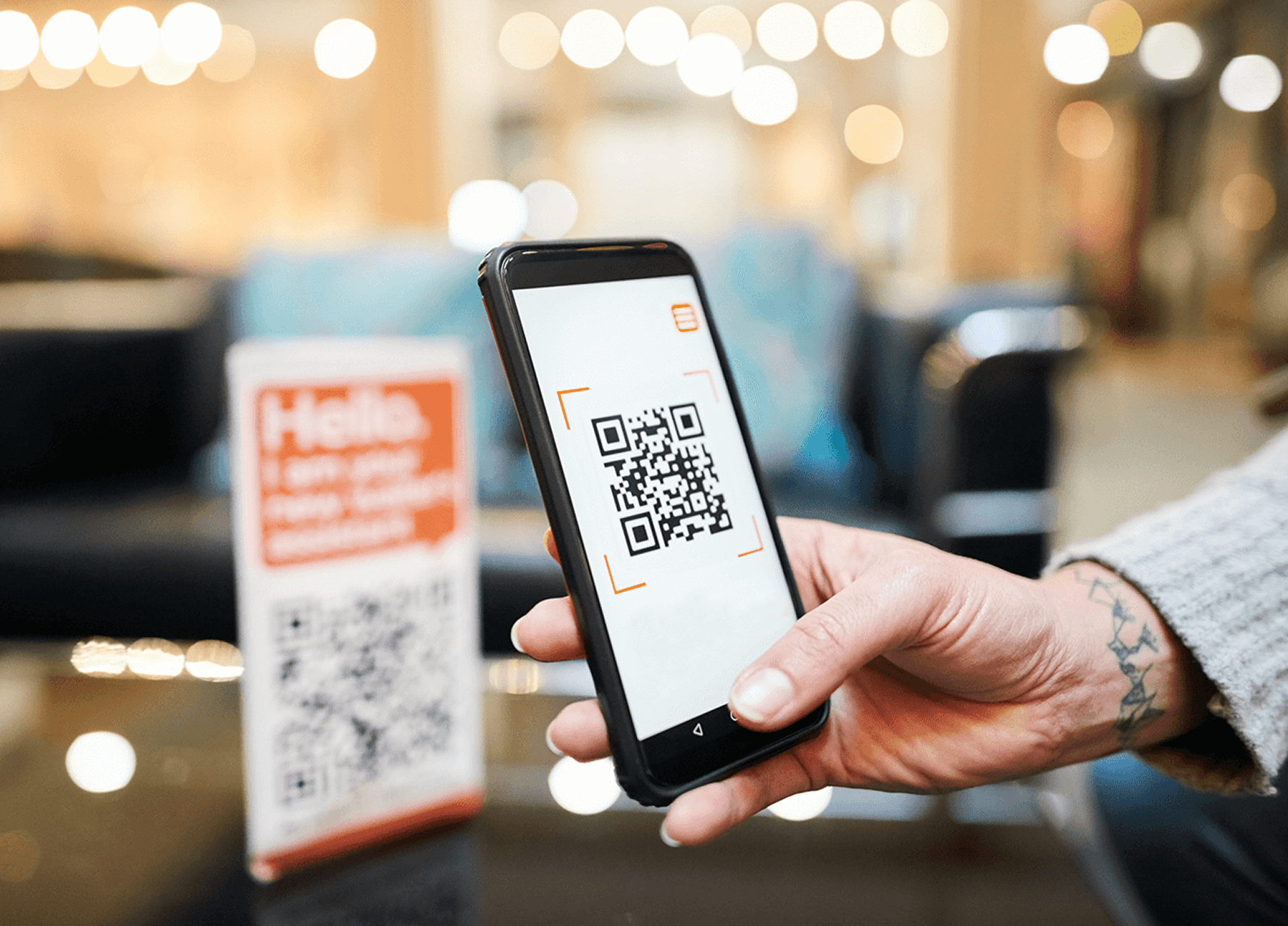 Hand holding phone, scanning QR code