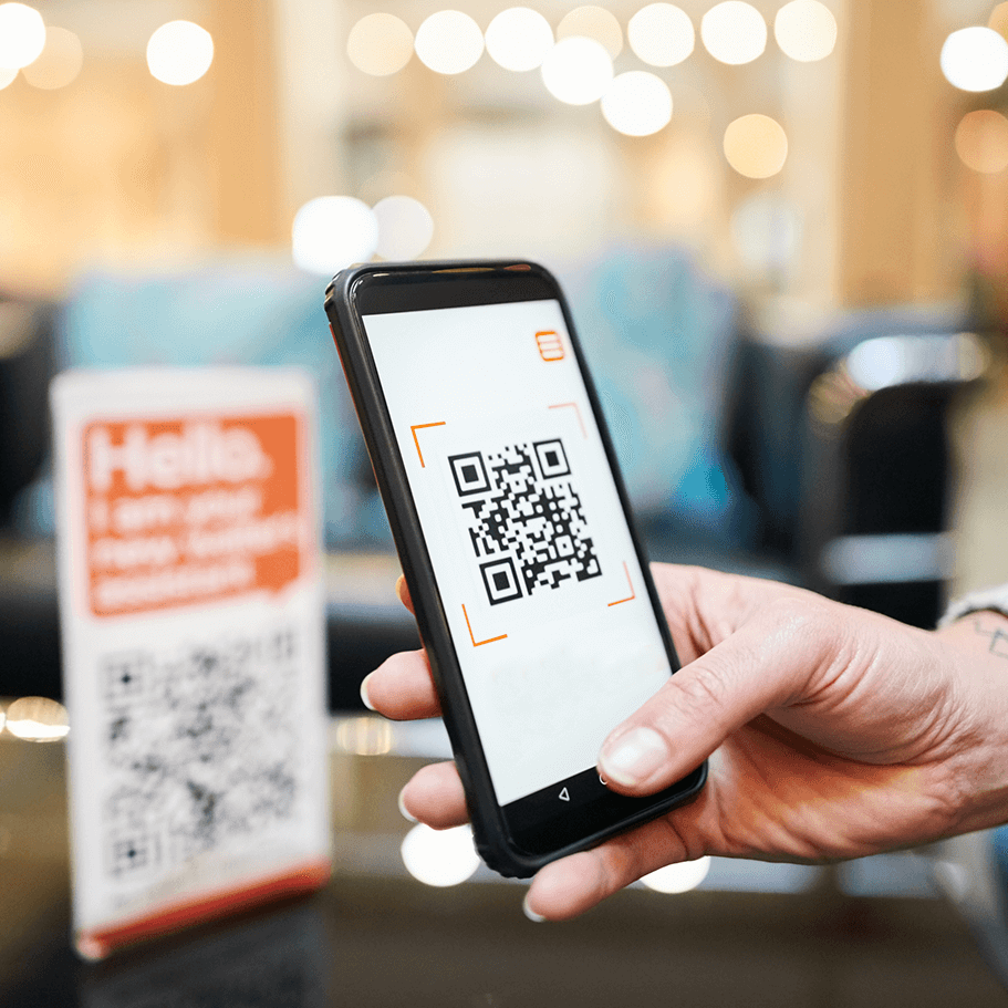 Hand scanning QR code with smartphone.