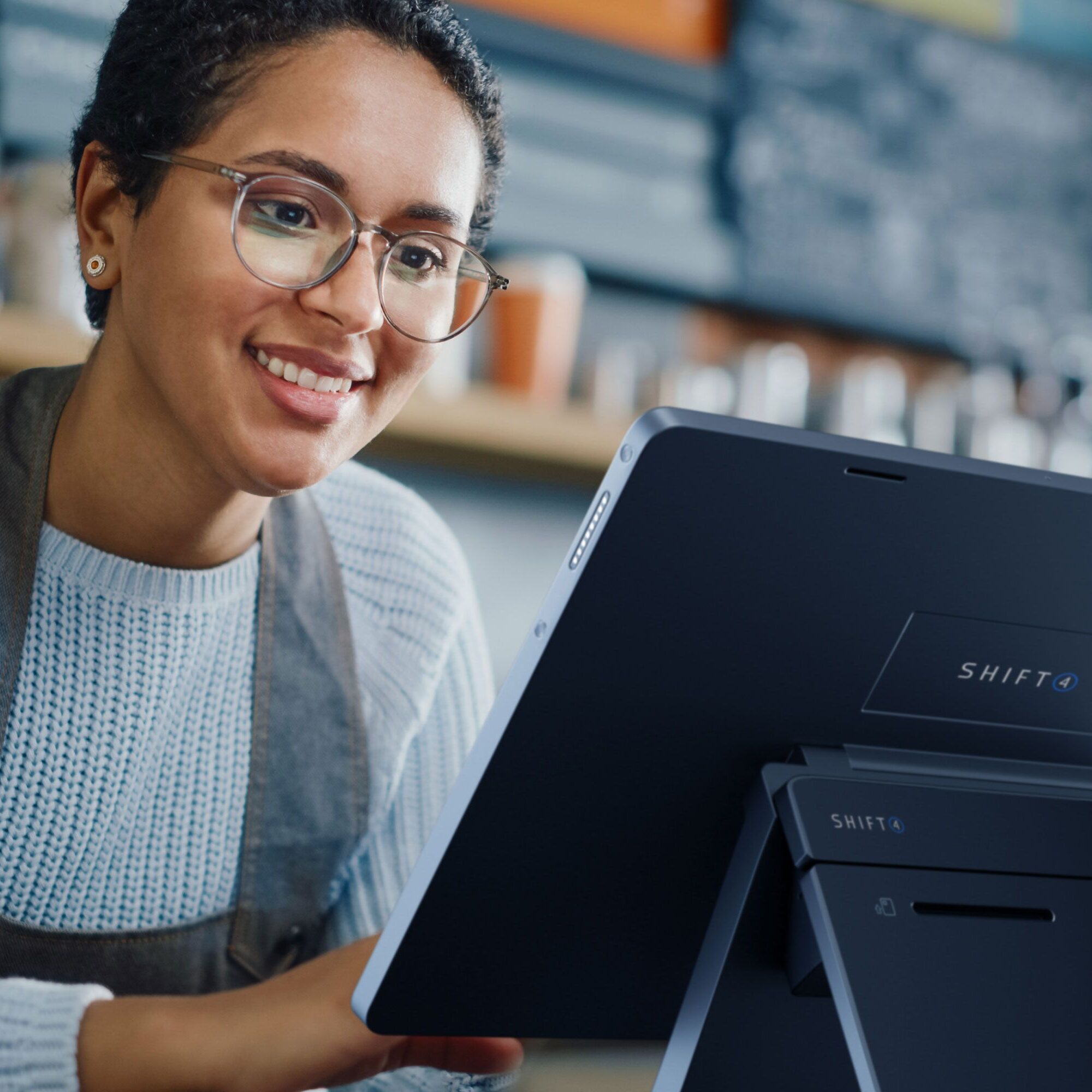 Woman smiling while using touchscreen device.