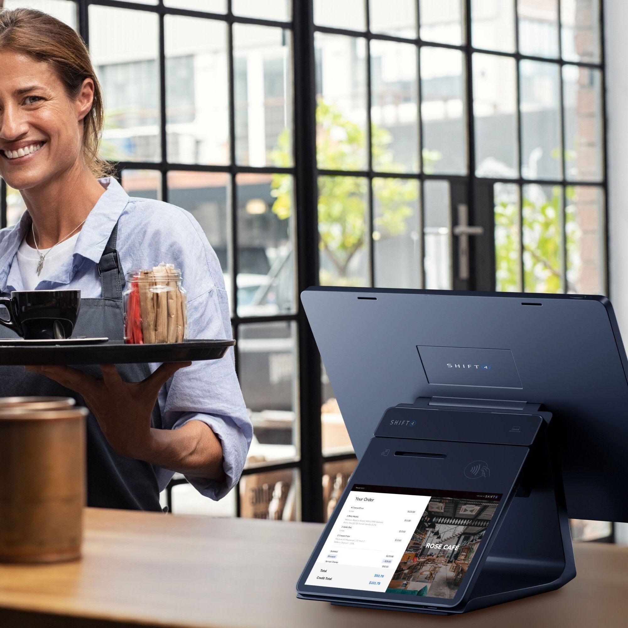Barista serving coffee near digital menu display.