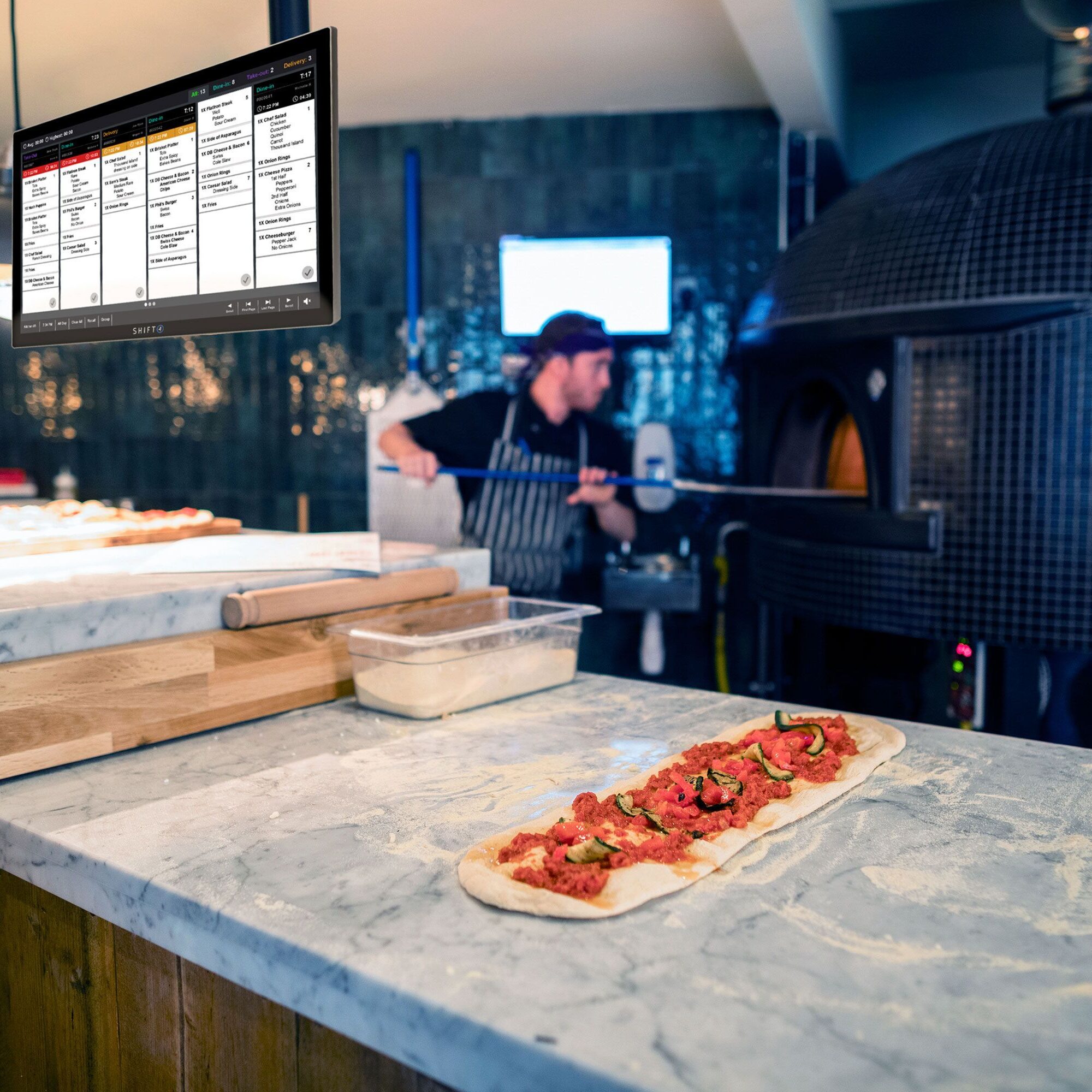 Pizza preparation near a wood-fired oven.