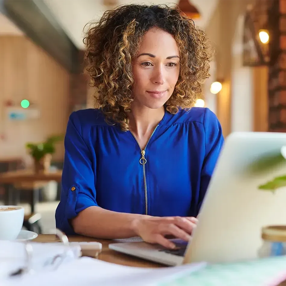Woman working on laptop in cozy cafe.
